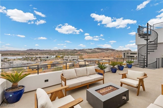 view of patio / terrace featuring stairway, a mountain view, and an outdoor living space with a fire pit