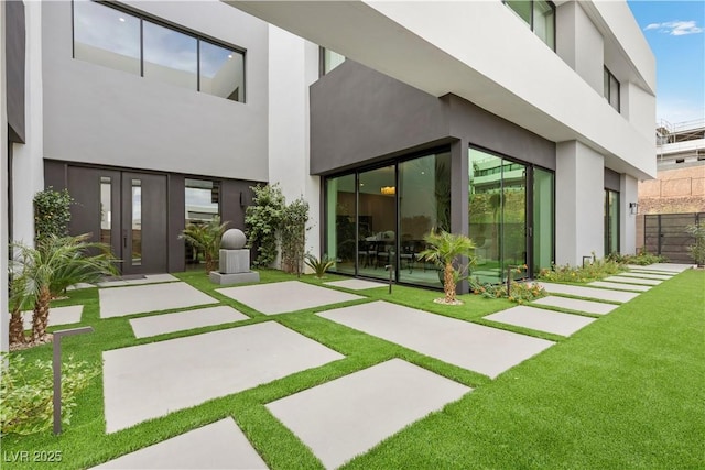 back of property with a patio area, fence, a lawn, and stucco siding