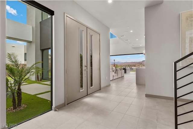 hall featuring light tile patterned floors, baseboards, and recessed lighting