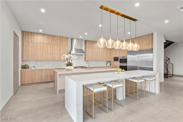 kitchen featuring a breakfast bar, decorative light fixtures, a spacious island, modern cabinets, and wall chimney exhaust hood