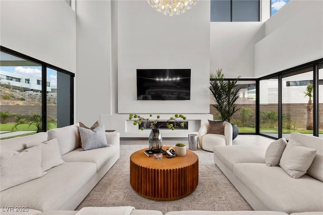 living room featuring a high ceiling, a wealth of natural light, and a notable chandelier