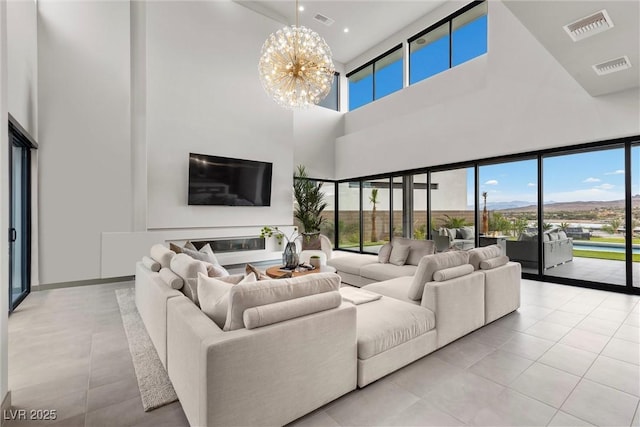 living room featuring light tile patterned flooring, visible vents, and an inviting chandelier