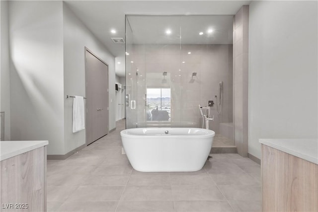 bathroom with a stall shower, visible vents, tile patterned floors, vanity, and a freestanding tub