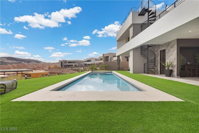 outdoor pool with a patio area, stairs, and a yard