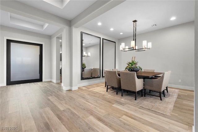 dining space featuring a notable chandelier and light wood-type flooring