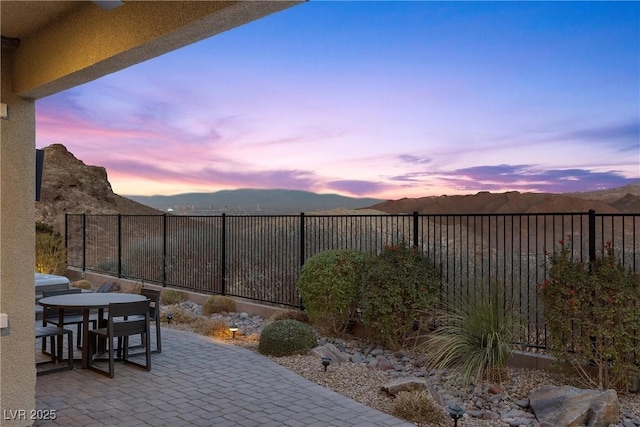 patio terrace at dusk featuring a mountain view