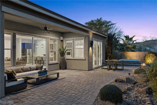 patio terrace at dusk featuring an outdoor hangout area and ceiling fan