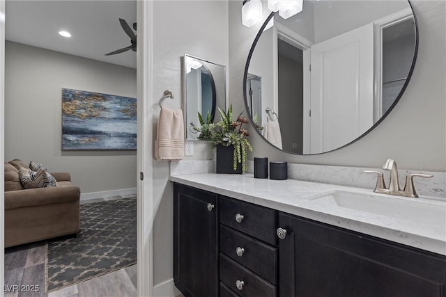 bathroom featuring hardwood / wood-style flooring, ceiling fan, and vanity