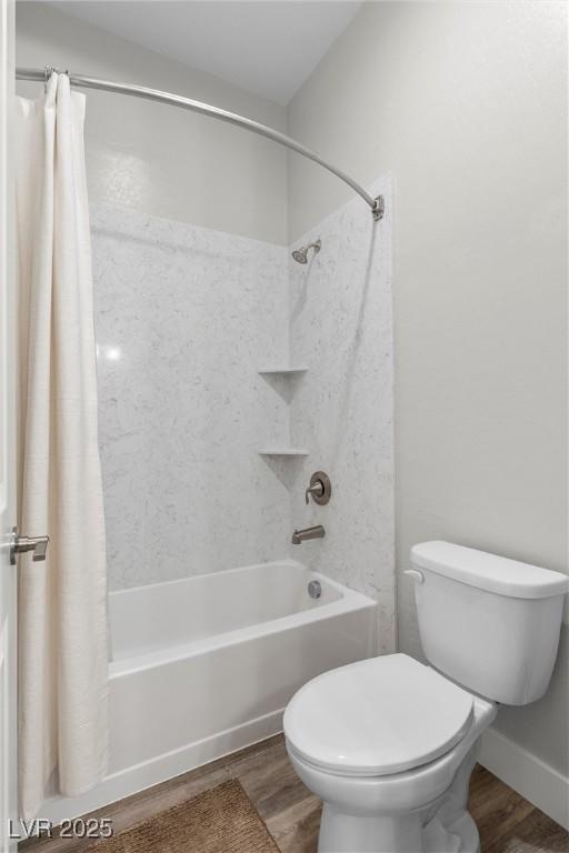 bathroom with wood-type flooring, shower / tub combo, and toilet