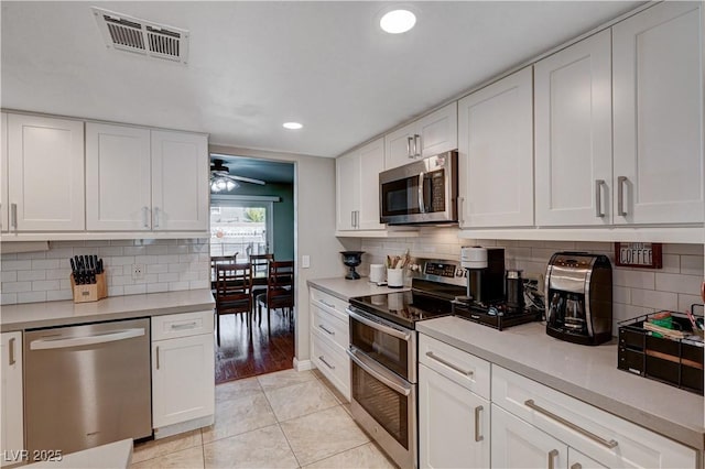 kitchen featuring ceiling fan, light tile patterned floors, stainless steel appliances, and white cabinets