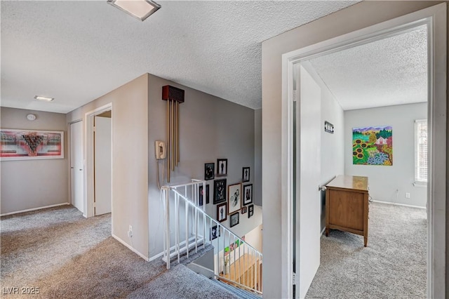 corridor featuring light colored carpet and a textured ceiling