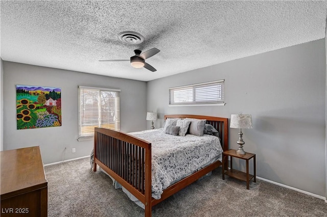 bedroom with ceiling fan, carpet floors, and a textured ceiling