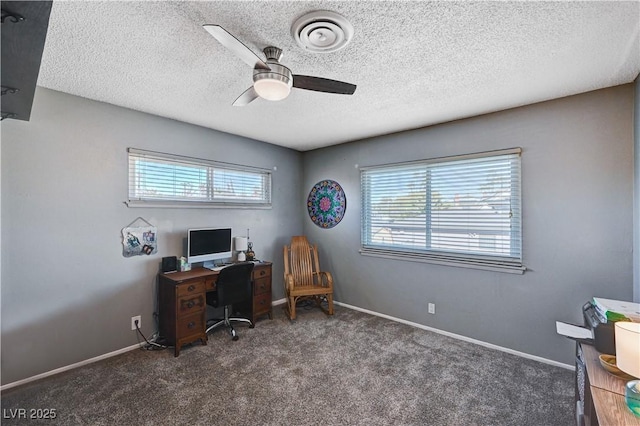 home office featuring ceiling fan, plenty of natural light, dark carpet, and a textured ceiling