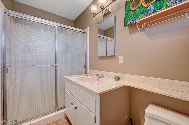 bathroom featuring vanity, an enclosed shower, and toilet