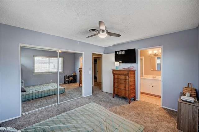 bedroom with carpet floors, sink, ceiling fan, a textured ceiling, and a closet