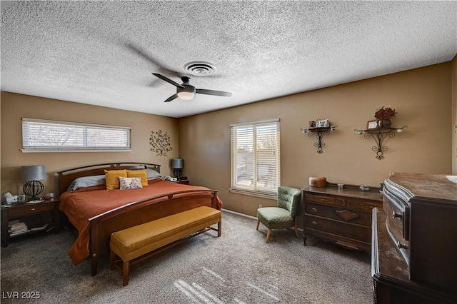 bedroom with multiple windows, a textured ceiling, carpet floors, and ceiling fan