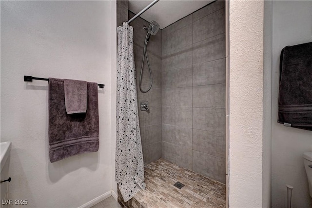 bathroom featuring toilet and a shower with shower curtain