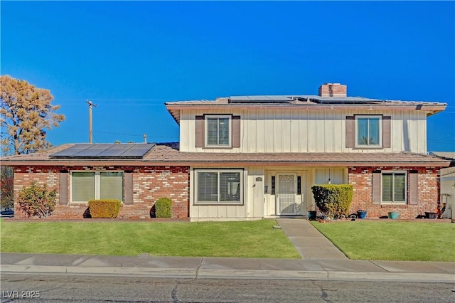 view of front of house featuring a front yard and solar panels