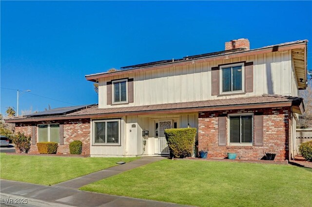 view of front of home featuring a front yard and solar panels