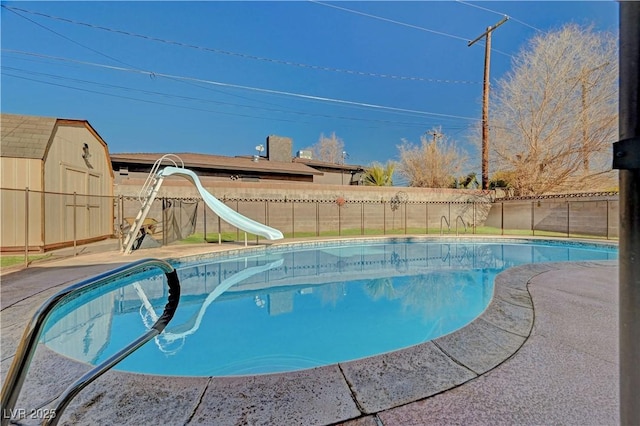 view of pool with a storage shed and a water slide