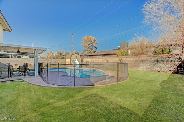 view of swimming pool featuring a patio area, a lawn, and a water slide