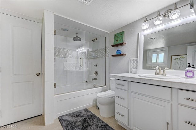 full bathroom with vanity, a textured ceiling, bath / shower combo with glass door, and toilet