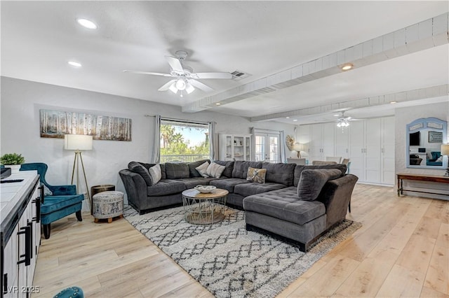 living room featuring ceiling fan, beam ceiling, and light hardwood / wood-style floors