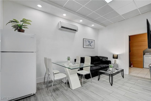 dining area featuring a wall mounted air conditioner and washer / clothes dryer