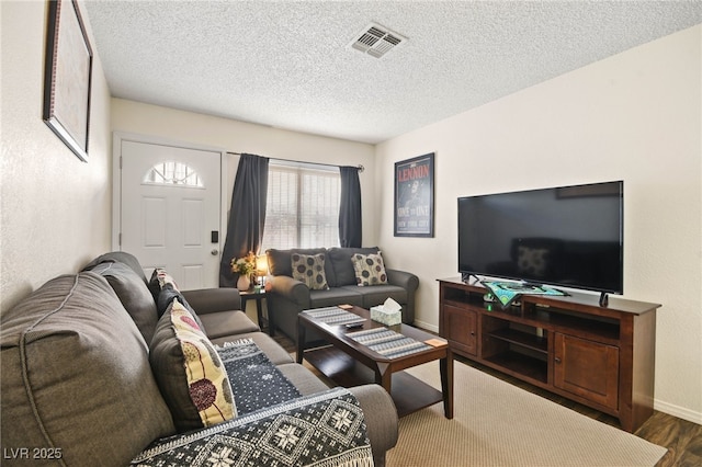 living room featuring dark hardwood / wood-style flooring and a textured ceiling