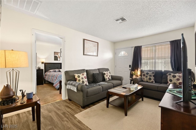 living room with hardwood / wood-style flooring and a textured ceiling