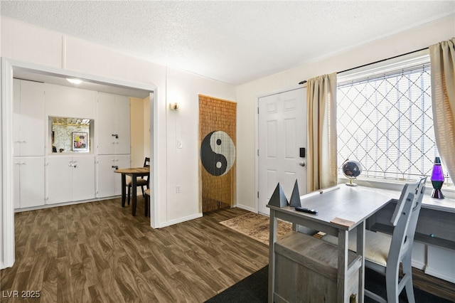 dining room featuring dark wood-type flooring and a textured ceiling