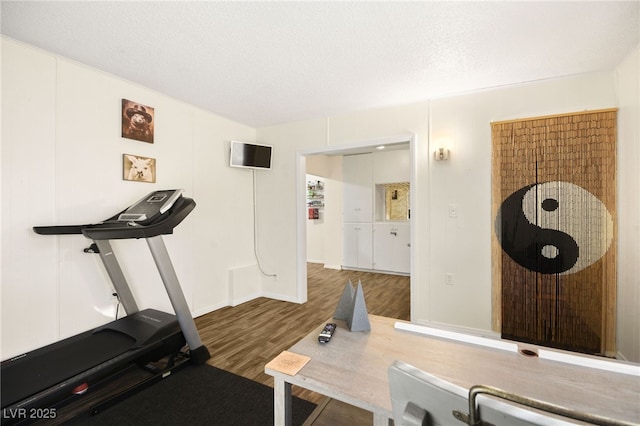 workout room featuring dark hardwood / wood-style flooring and a textured ceiling