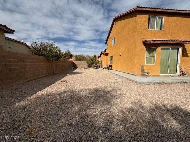 view of side of home featuring a fenced backyard and stucco siding