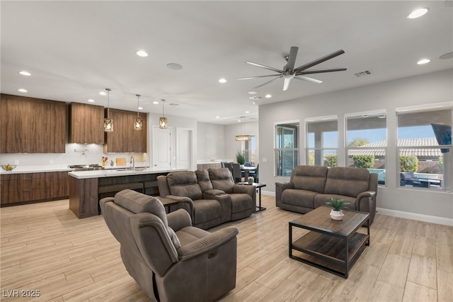 living room featuring ceiling fan and light wood-type flooring