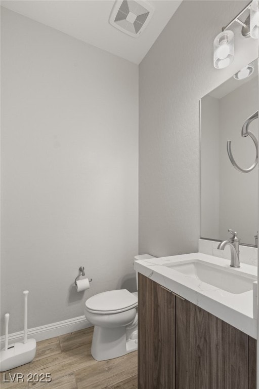 bathroom featuring vanity, toilet, and hardwood / wood-style floors