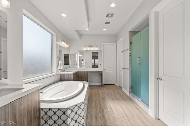 bathroom with vanity, independent shower and bath, and hardwood / wood-style floors