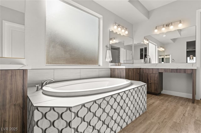 bathroom featuring hardwood / wood-style flooring and tiled bath