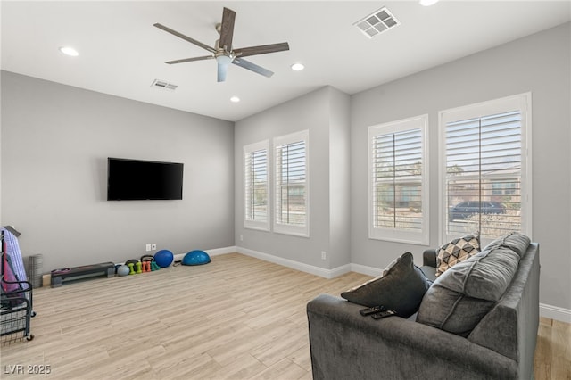 living room with light hardwood / wood-style floors and ceiling fan