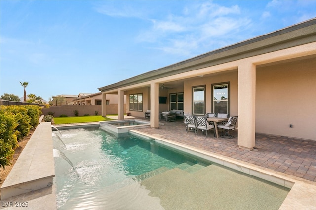 view of swimming pool with an in ground hot tub, pool water feature, ceiling fan, and a patio area