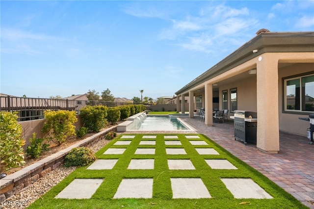 view of swimming pool with a patio, pool water feature, and area for grilling