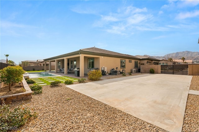 back of property featuring a fenced in pool, a patio, and a mountain view