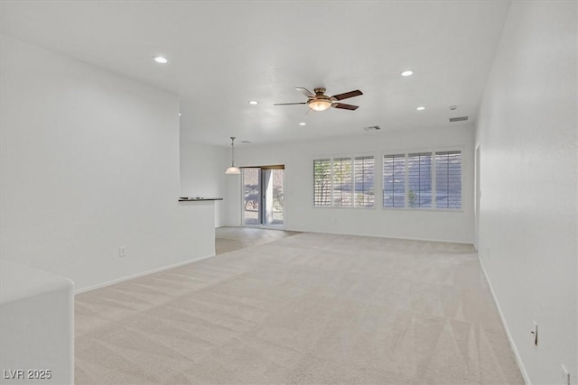 unfurnished living room with light colored carpet and ceiling fan