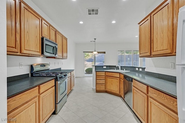 kitchen with stainless steel appliances, light tile patterned flooring, hanging light fixtures, and sink