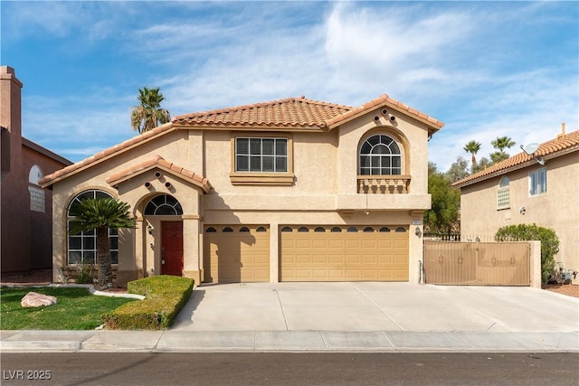 mediterranean / spanish home featuring fence, a tiled roof, concrete driveway, stucco siding, and an attached garage