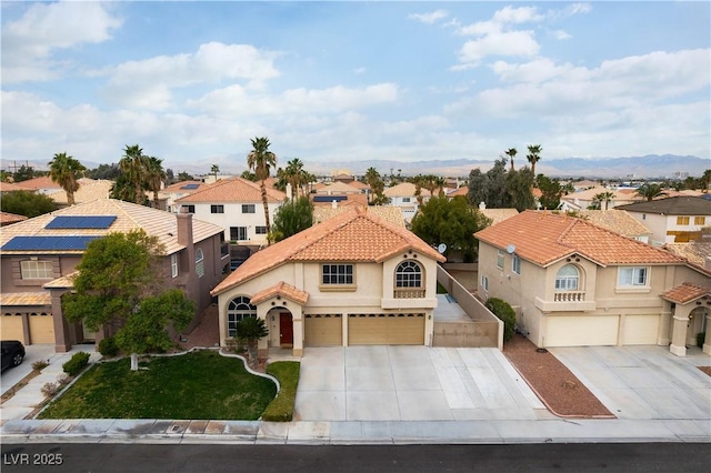 mediterranean / spanish-style house with a tiled roof, a residential view, stucco siding, and an attached garage