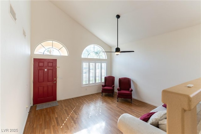 entryway featuring wood finished floors, baseboards, visible vents, high vaulted ceiling, and ceiling fan