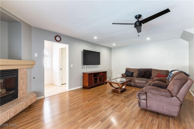 living area featuring recessed lighting, a fireplace, and light wood-style floors