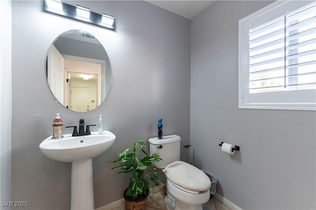 bathroom with a sink, baseboards, and toilet