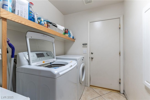 washroom with laundry area, light tile patterned flooring, separate washer and dryer, and visible vents