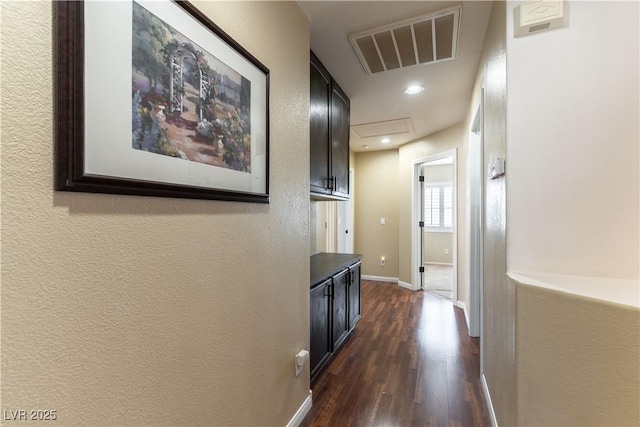 hallway with baseboards, visible vents, recessed lighting, dark wood-type flooring, and a textured wall